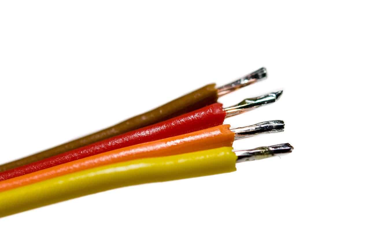 Four tinned copper wires (brown, red, orange, yellow insulation) fanned out on white.